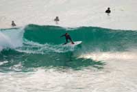 Malibu rider on a wave and others 'out back'